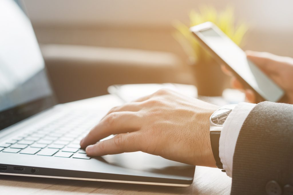 biurowy-desktop-z-laptopem-i-biznesowym-mezczyzna